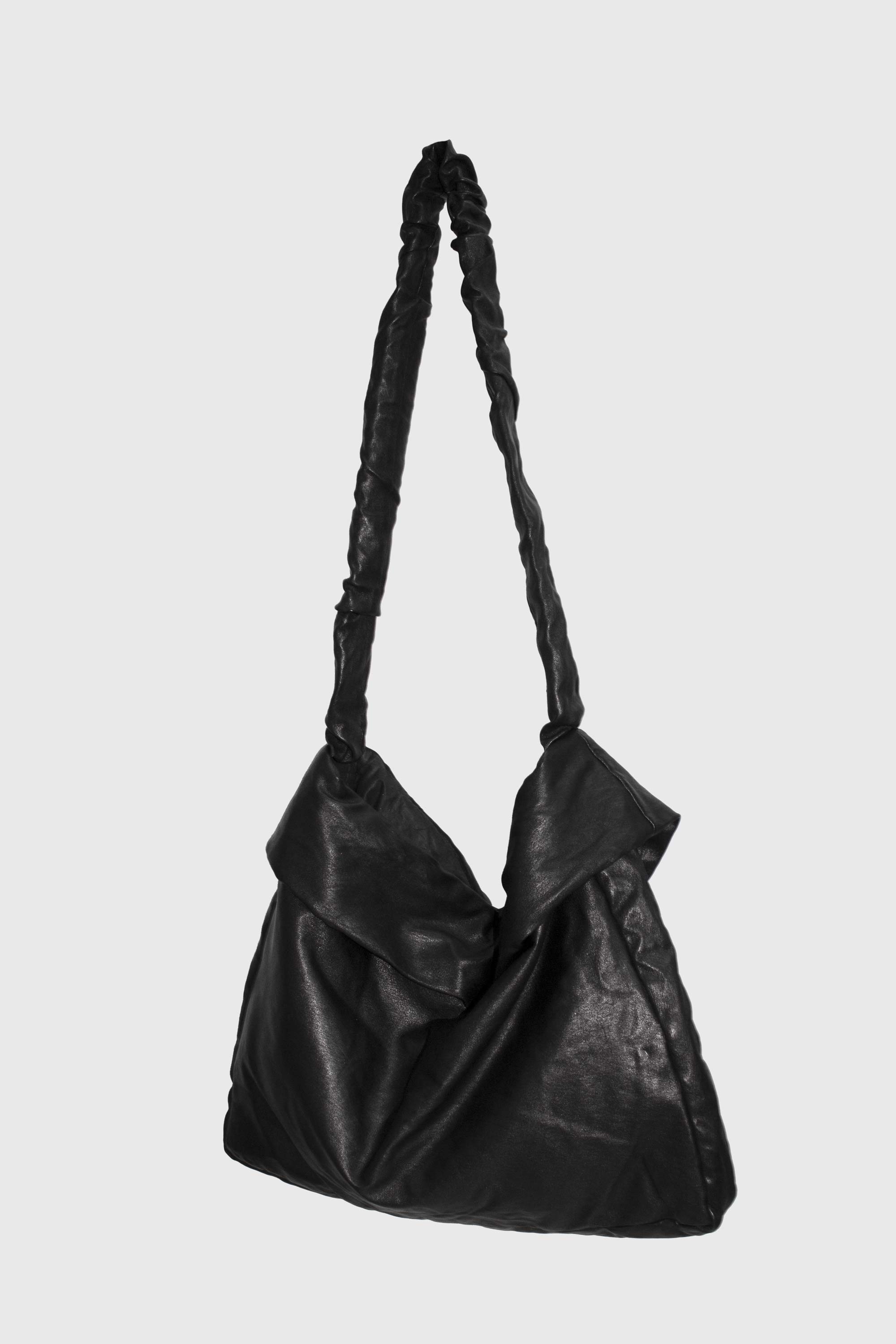 Full view of black leather bag showing slouched silhouette and strap detail