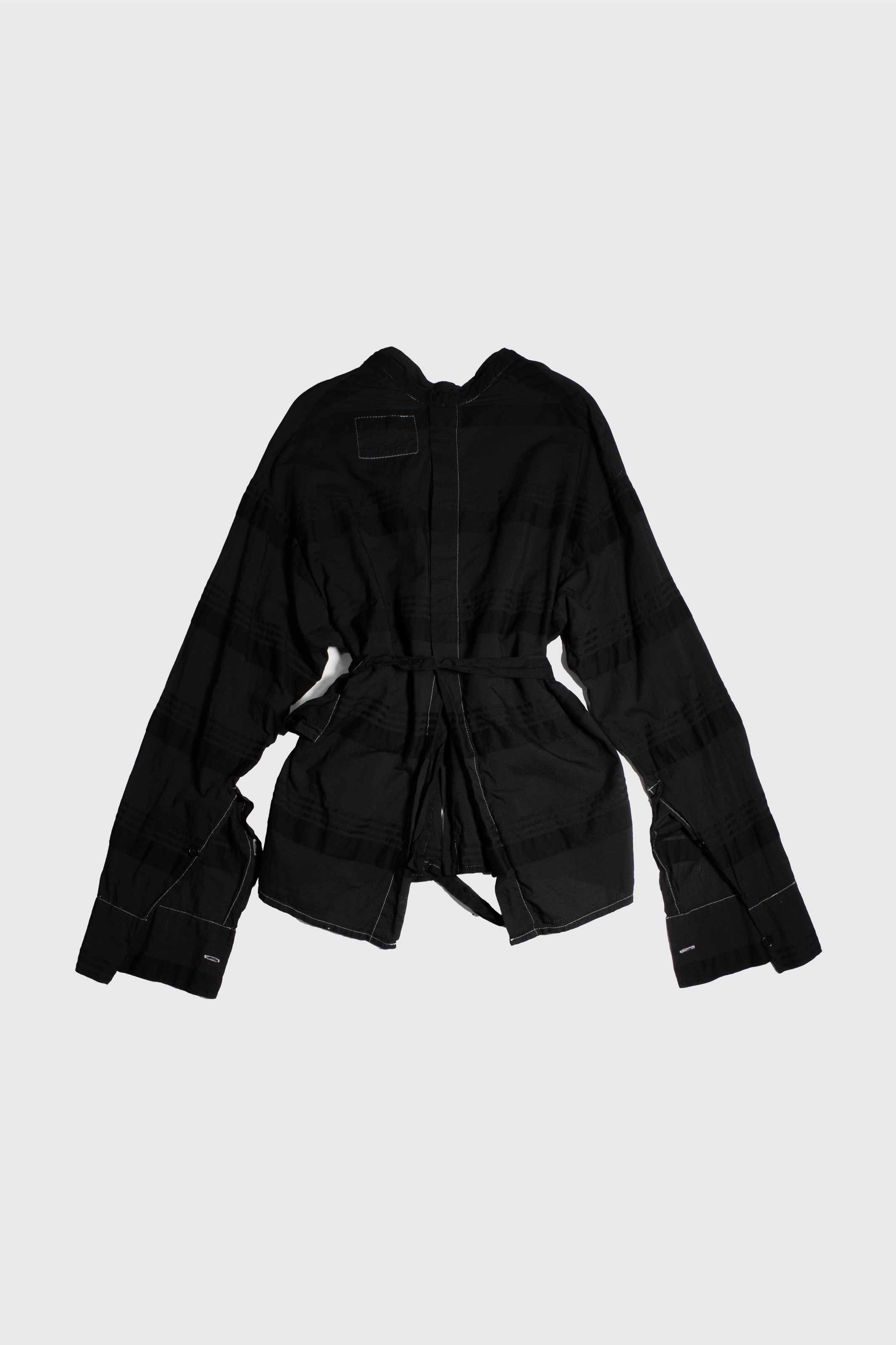 Back view of black shirt showing center back seam and self-tie waist belt with contrast topstitching detail