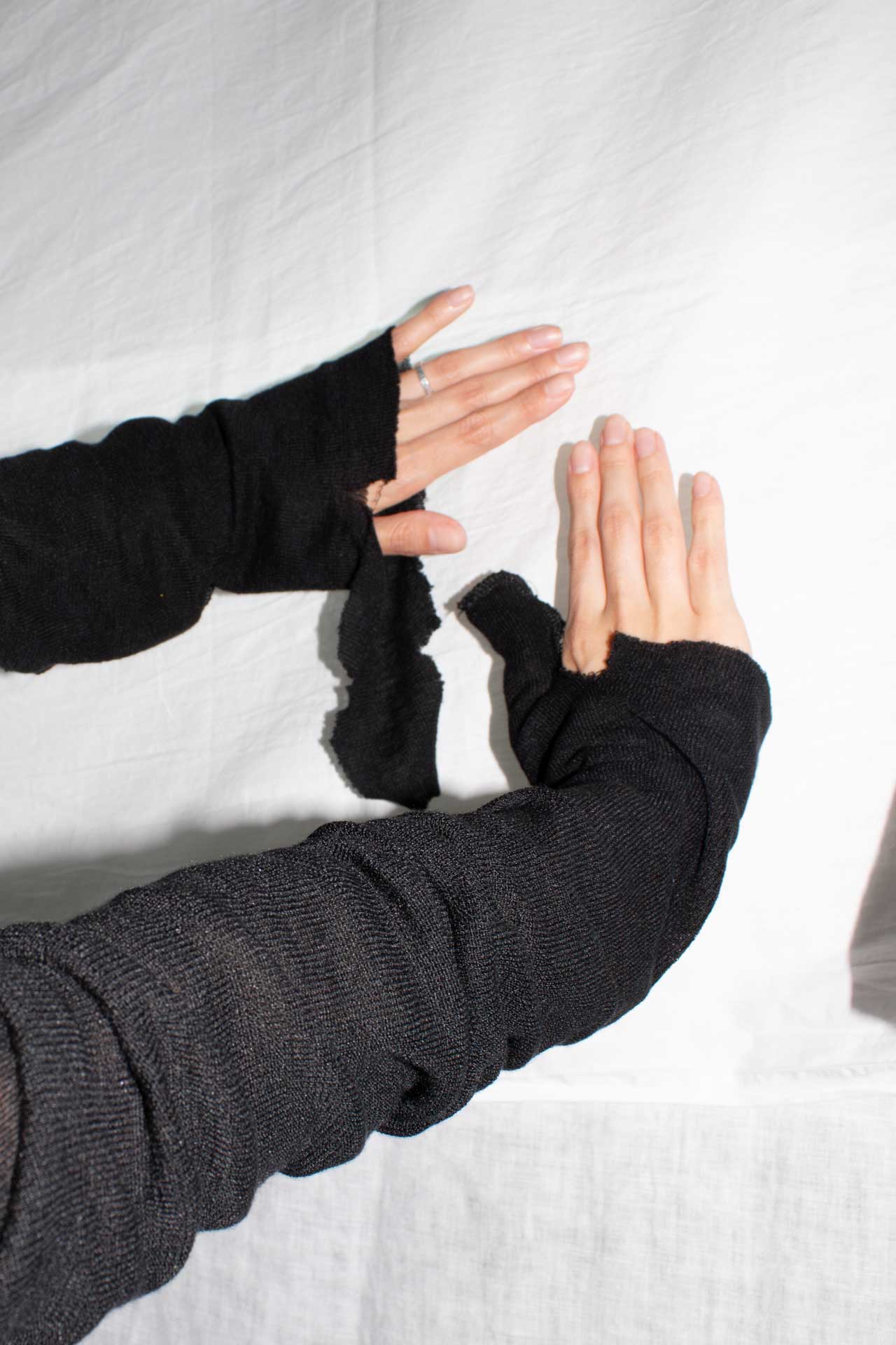 Close-up of extended sleeves with thumb openings and raw edges