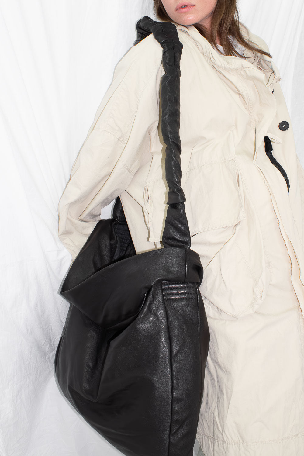 Model carrying black leather bag showing crossbody style and proportions