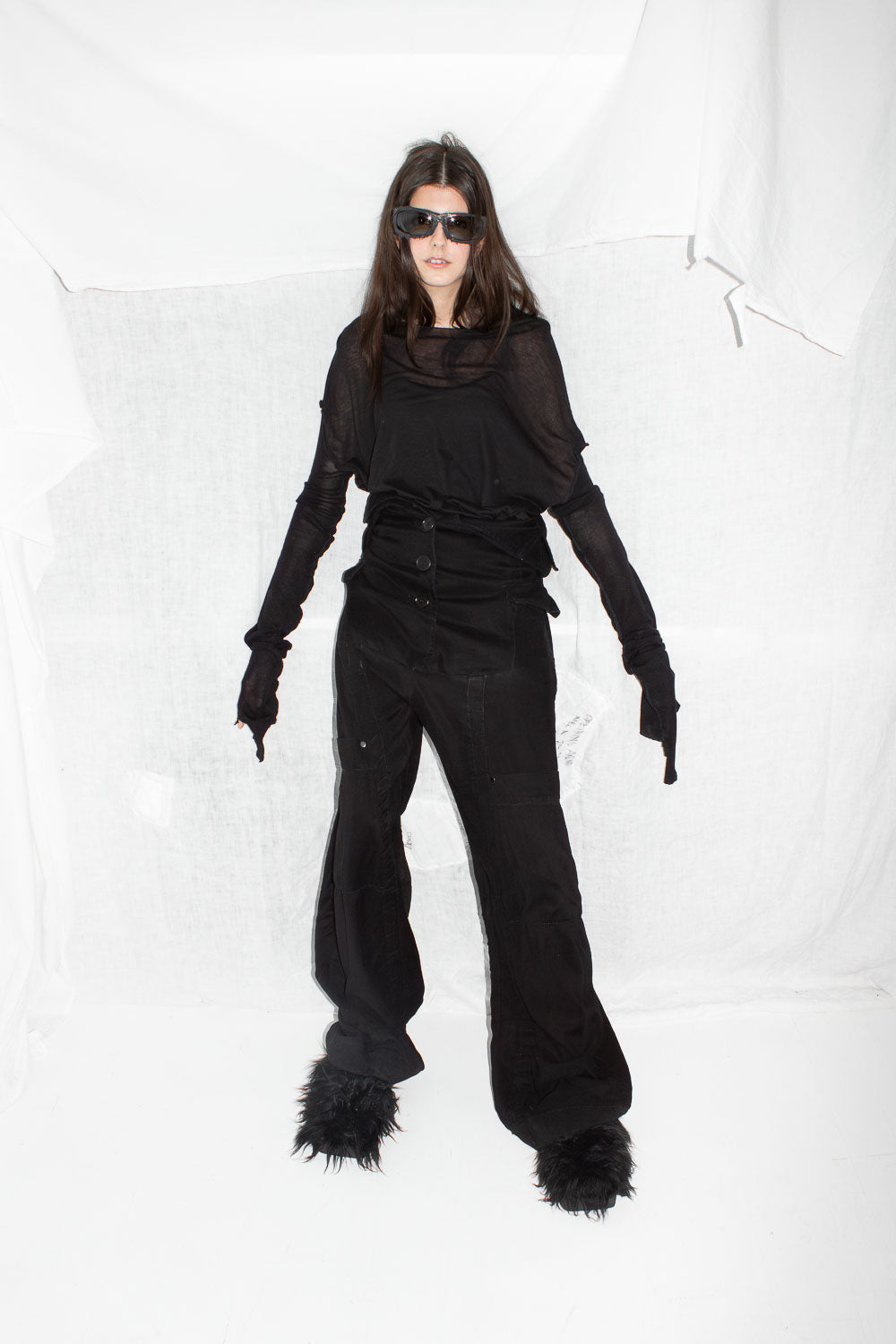 Full front view of model in complete styling with sunglasses and layered black pieces