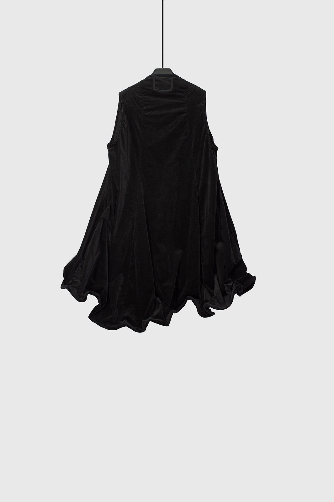 Three-quarter view highlighting the dress movement and architectural hem structure