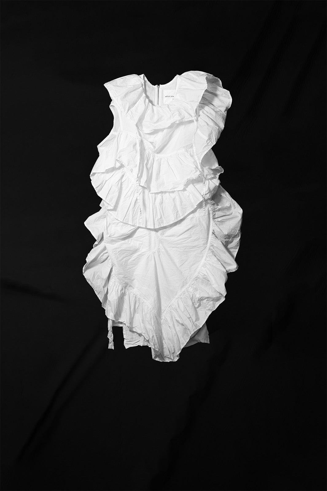 White sleeveless ruffle dress with asymmetric layered construction and raw edge detailing flat lay