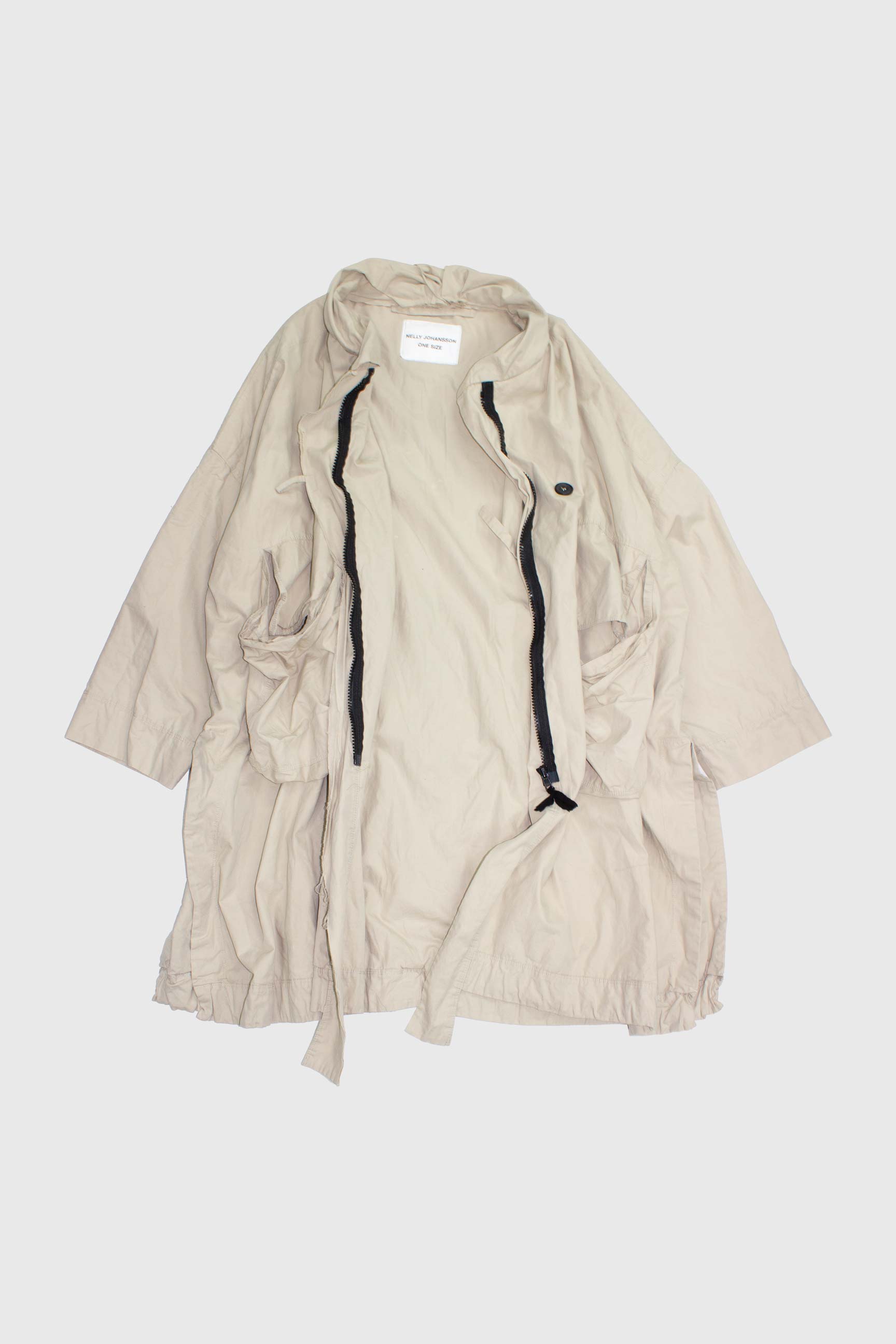 Beige parka open flat showing interior zipper construction and gathered hem detail