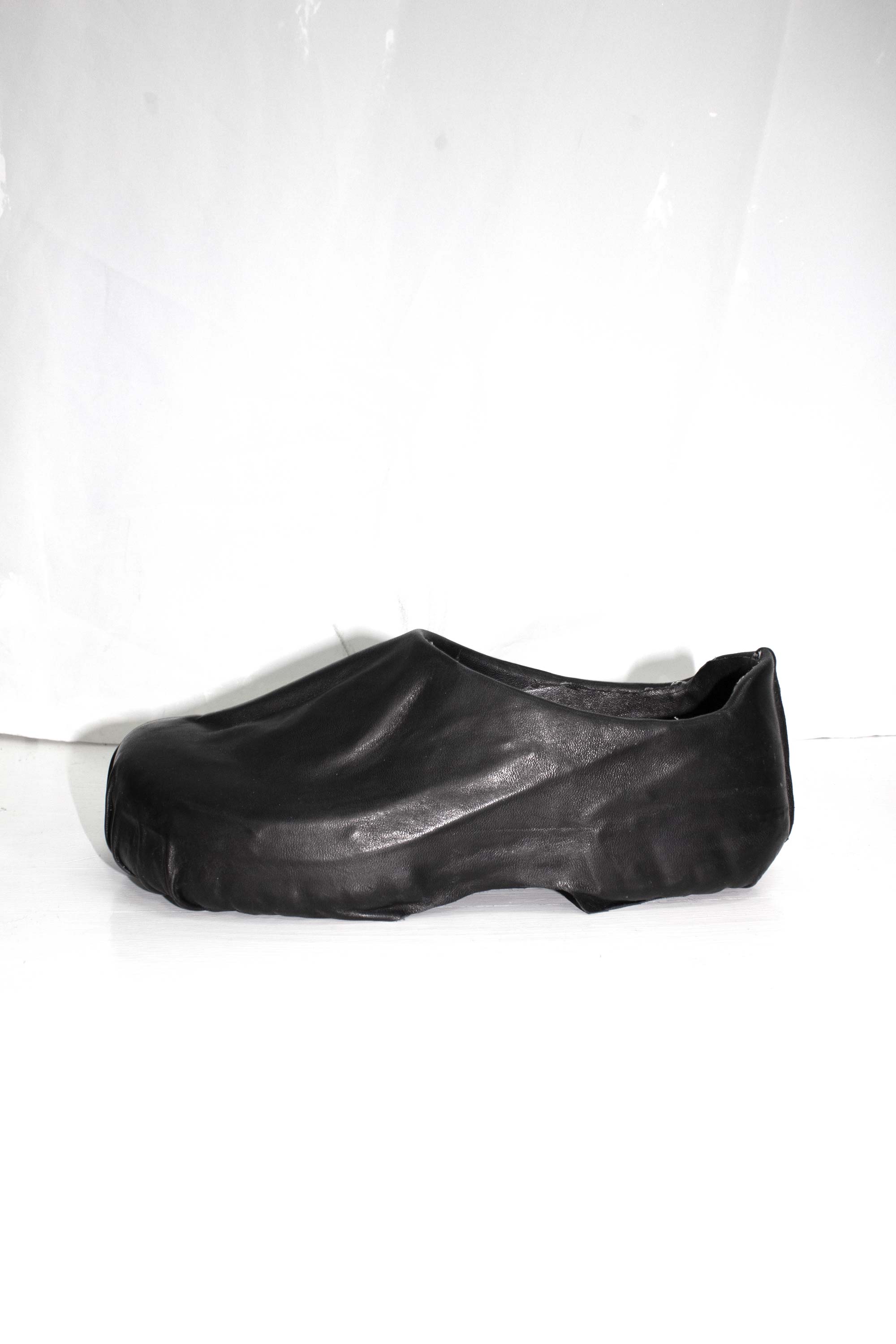 Black wrapped clog photographed from three-quarter view showing curved silhouette