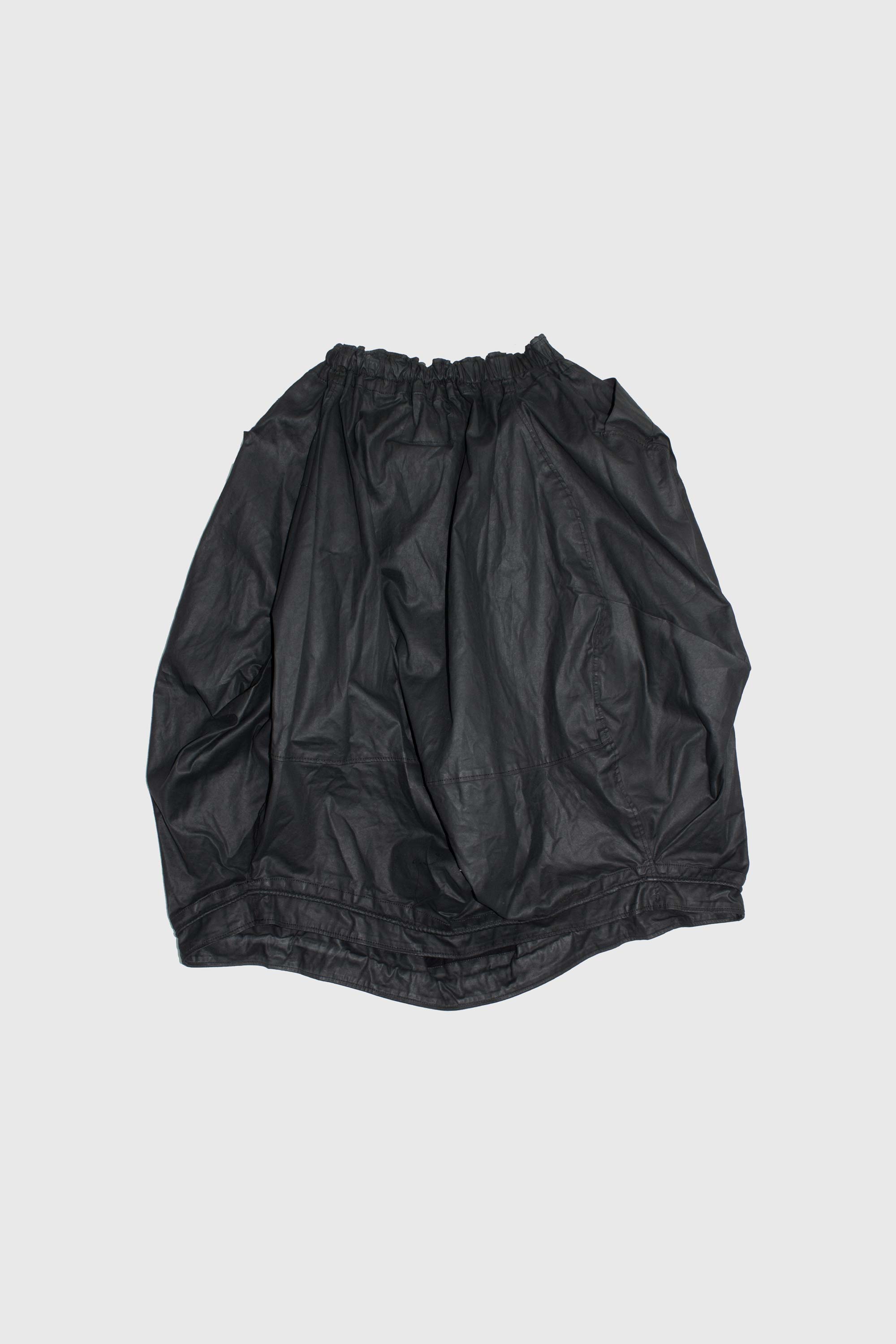 Black cotton top displayed flat showing full construction and elasticized opening detail