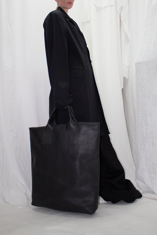 NELLY JOHANSSON 2023–24 collection: long black coat with a large black leather tote 4