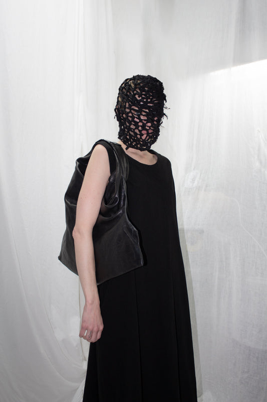 NELLY JOHANSSON 2023–24 collection: masked model in a black sleeveless dress with a black bag 33