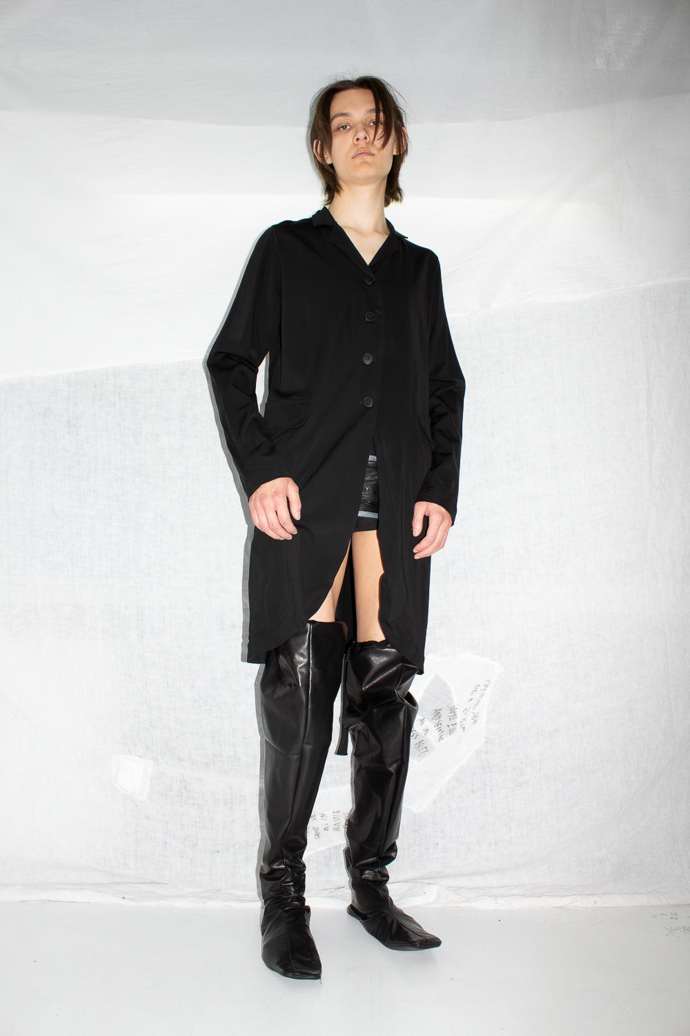 Model in black coat styled with leather boots, showing full-length proportions and straight fit