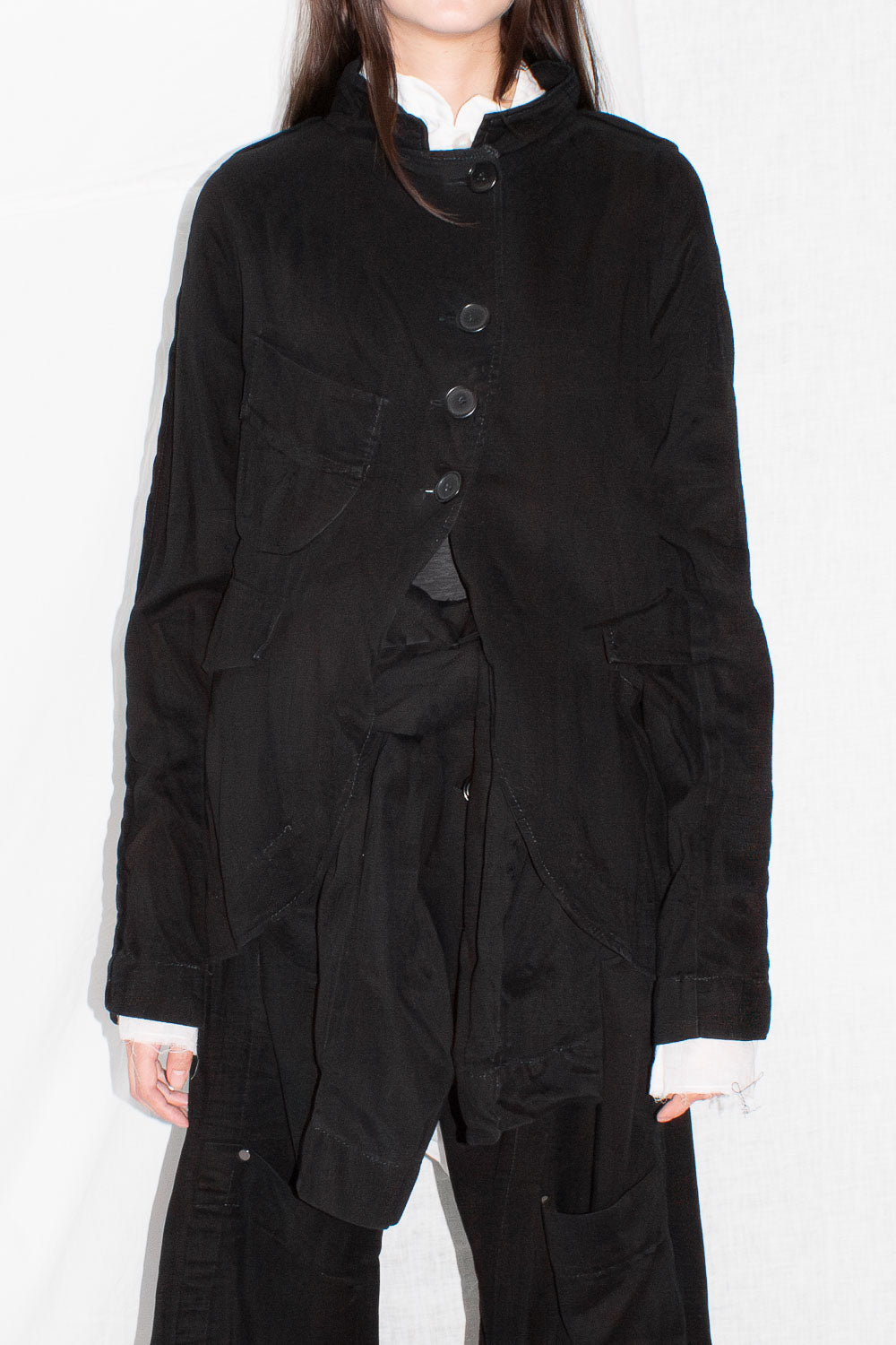 Close-up of jacket worn showing button closure detail and flap pocket construction