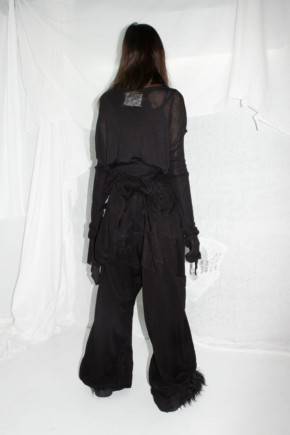 Back view of model showing blazer sleeve details and tie construction at waist