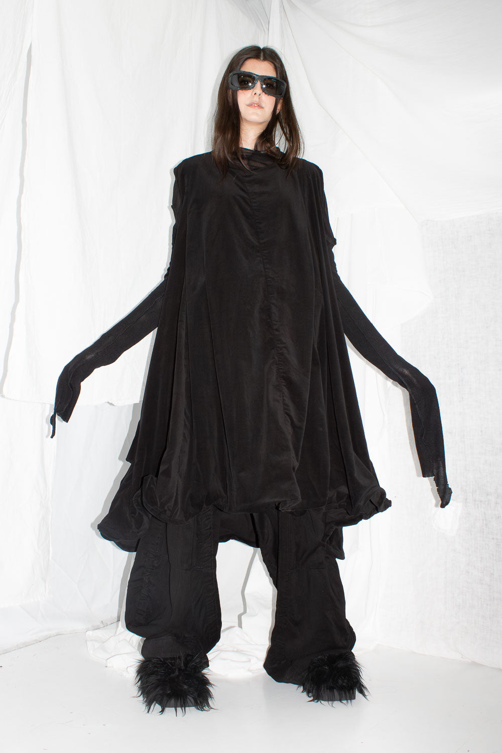 Back view of hanging dress showing wire-framed hem construction and sculptural draping