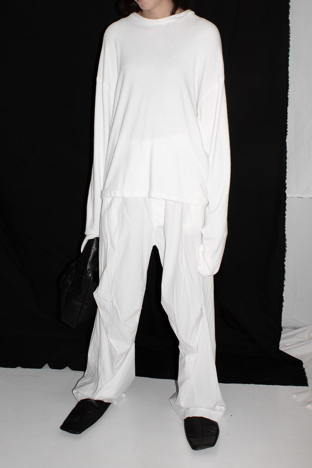 Full length view of model in white sweater paired with matching wide leg trousers