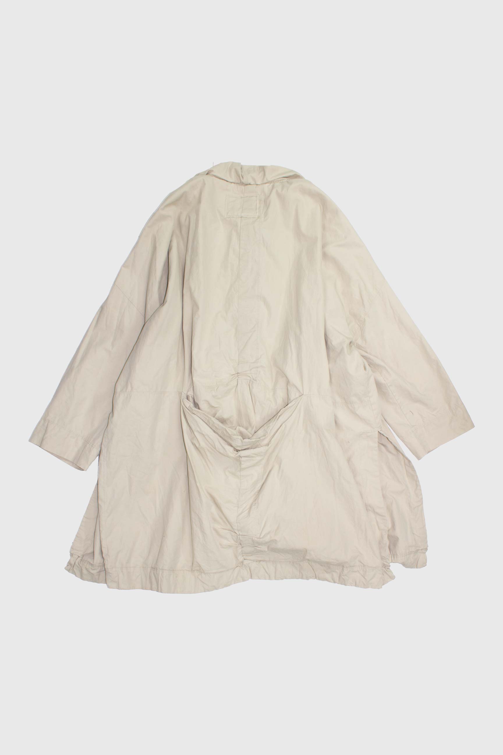 Back view of beige parka showing gathered hem and sculptural draping