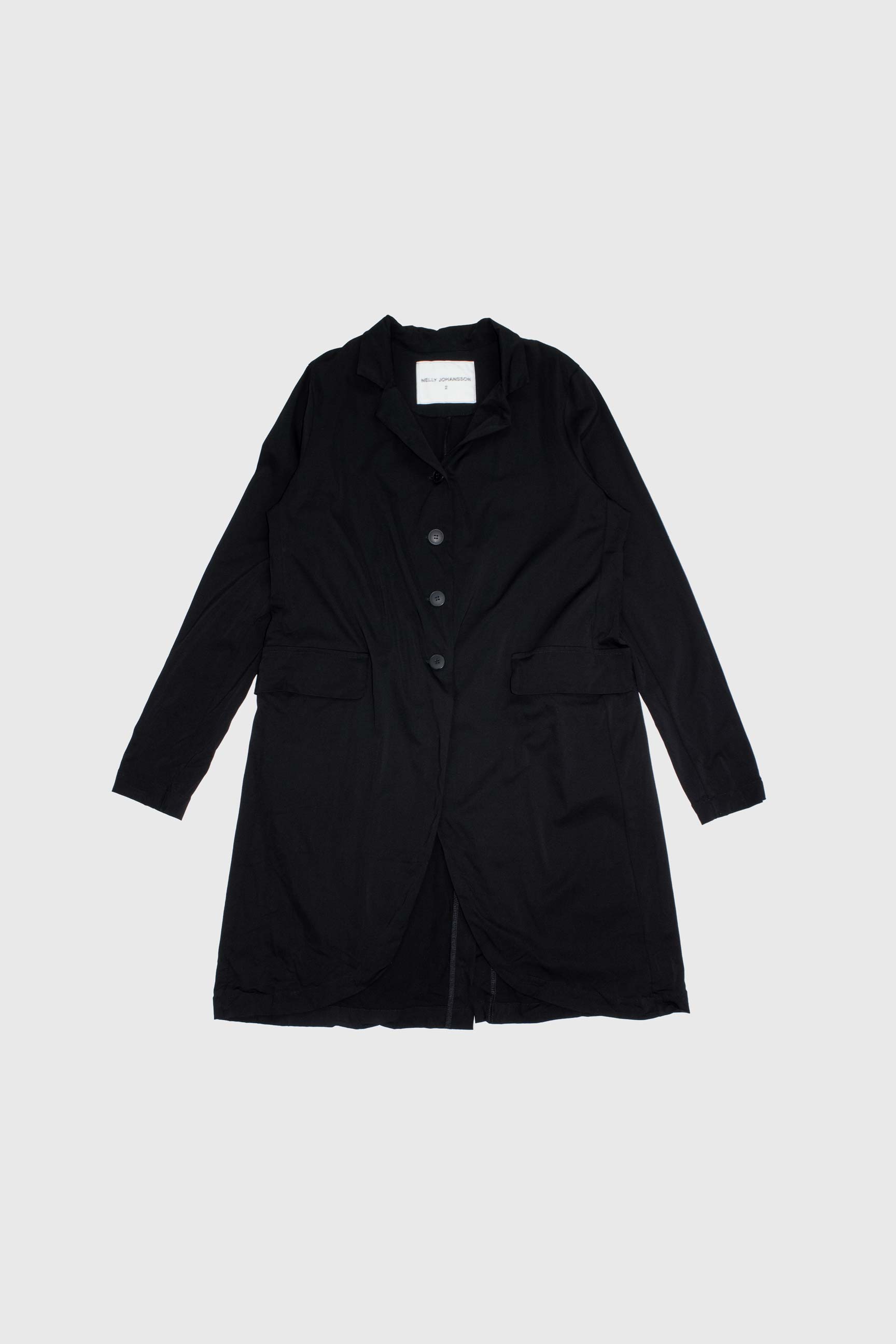 Black stretch coat laid flat showing front view with four buttons, notched collar and flap pockets