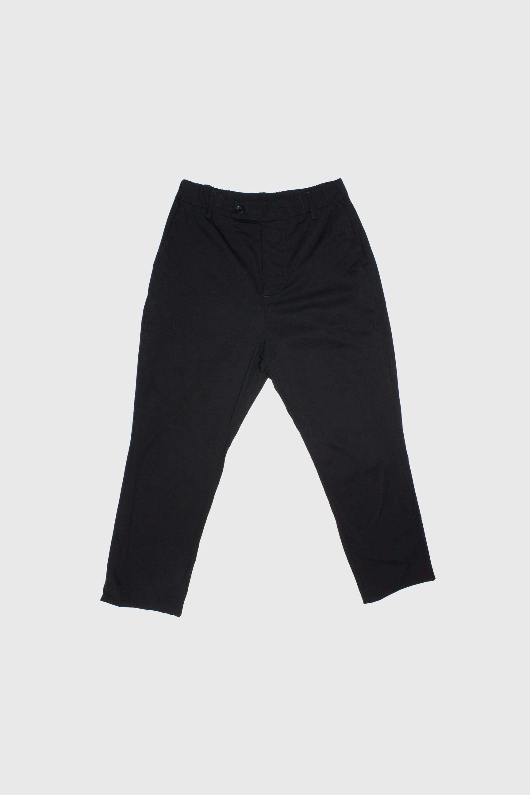Front view of black trousers flat lay showing angled side pockets and button closure